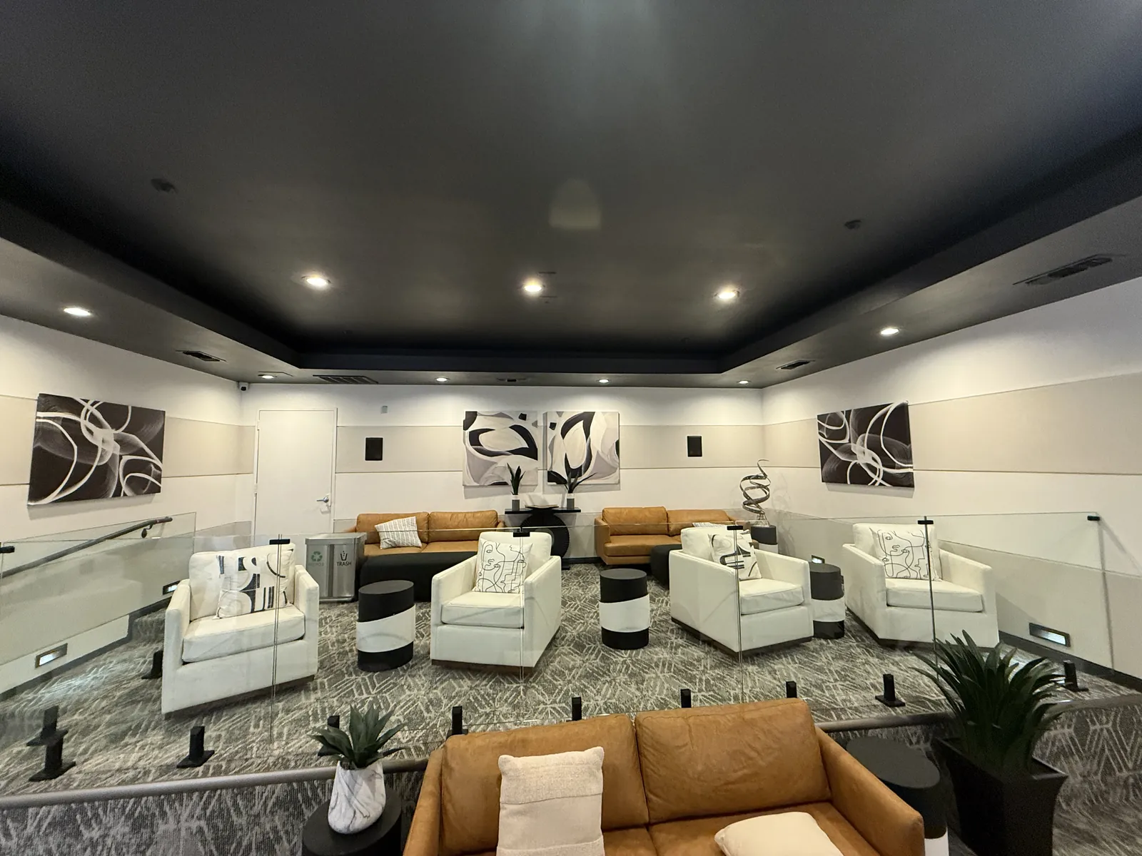 Glass guards with black mounts around tiered lounge seating