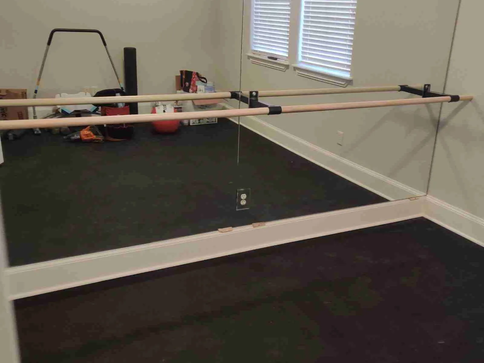 Full-height mirror wall with a ballet barre in an exercise room